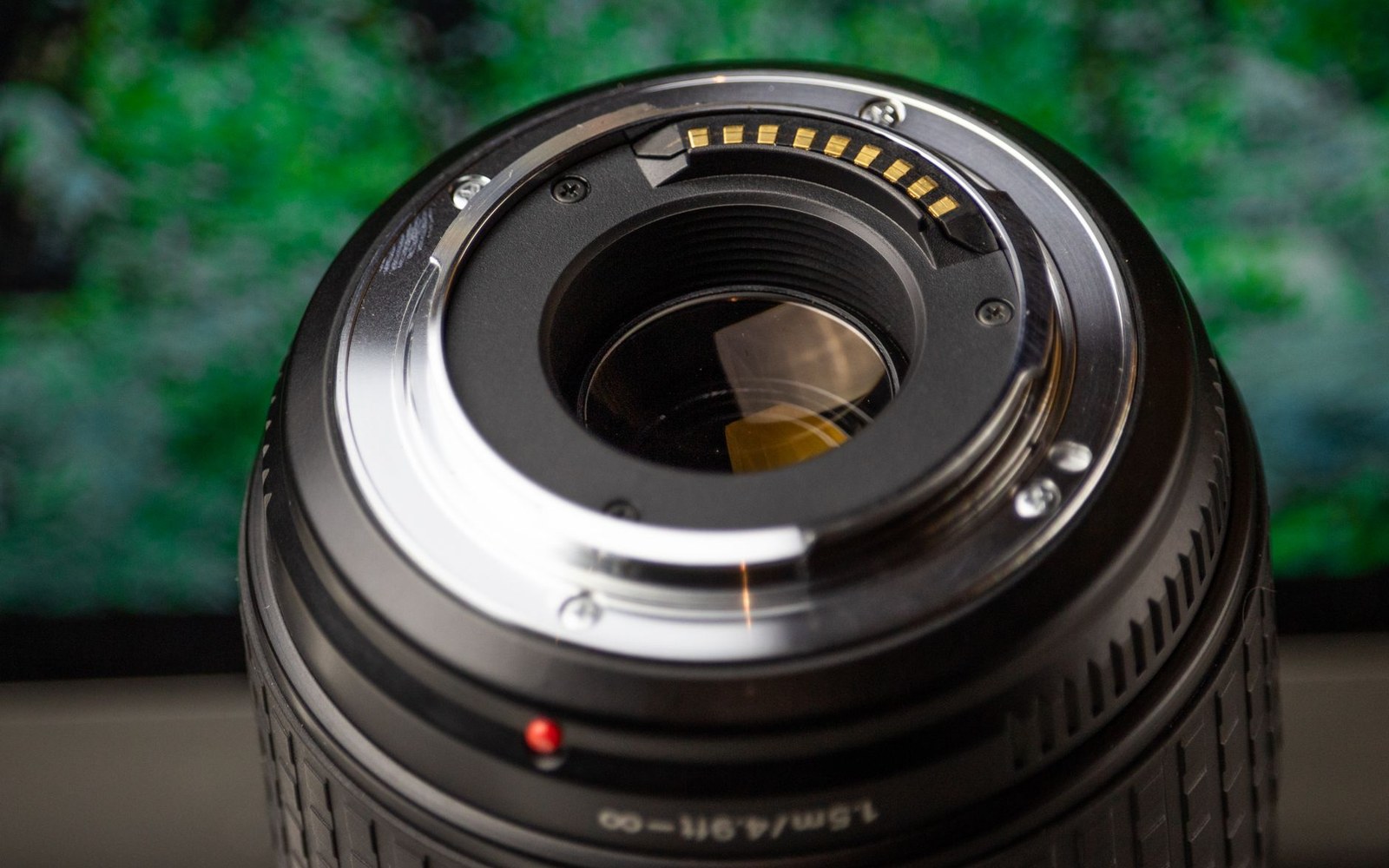 Close-up of a camera lens mount showing bayonet tabs and gold electronic contact pins