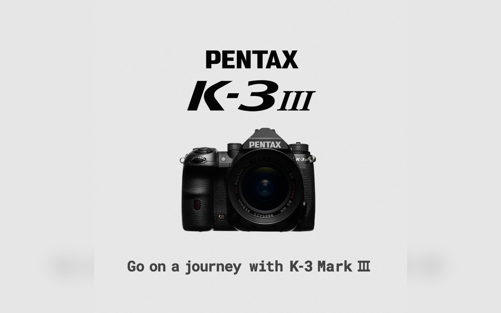 Pentax K-3 Mark III DSLR camera with attached lens against a plain gray background
