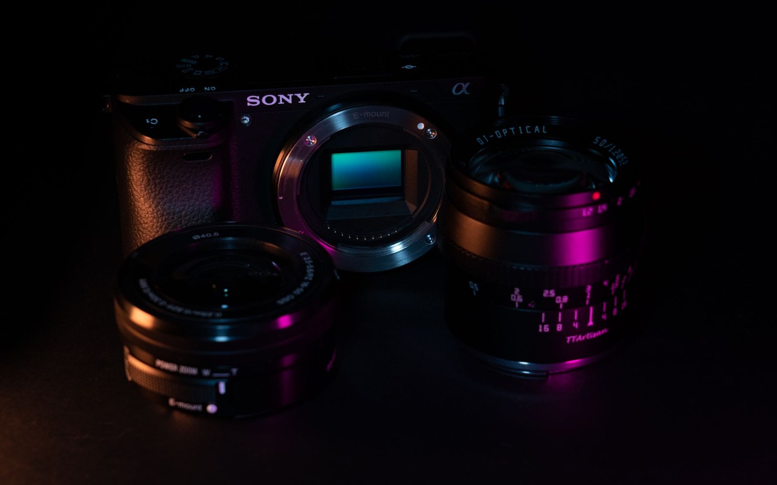 Sony mirrorless camera body with exposed sensor flanked by two detachable lenses