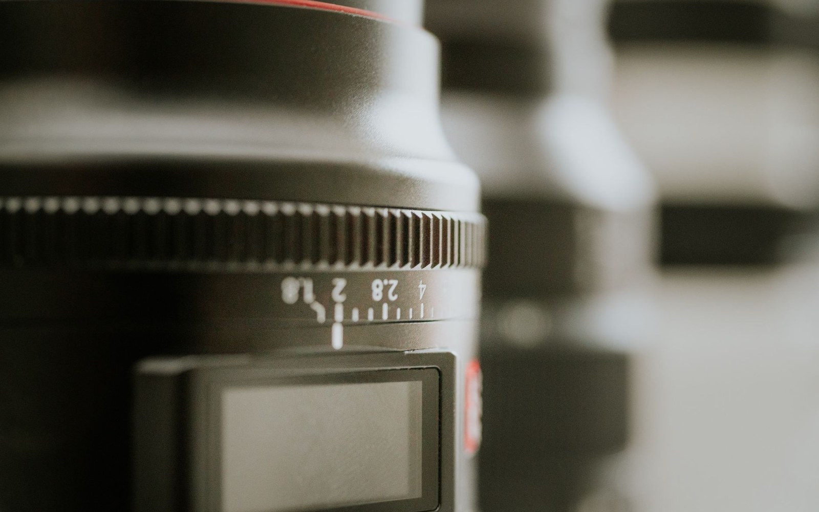 Close-up of a camera lens focus ring showing aperture markings and distance scale