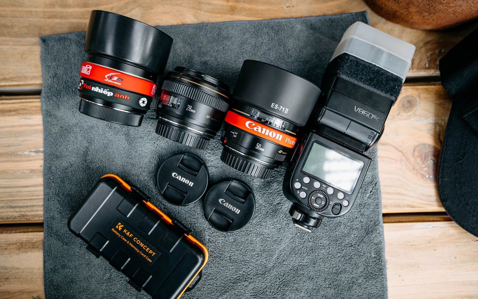 Adult photographer's open camera bag on a surface, K-mount bodies and DA lenses arranged inside